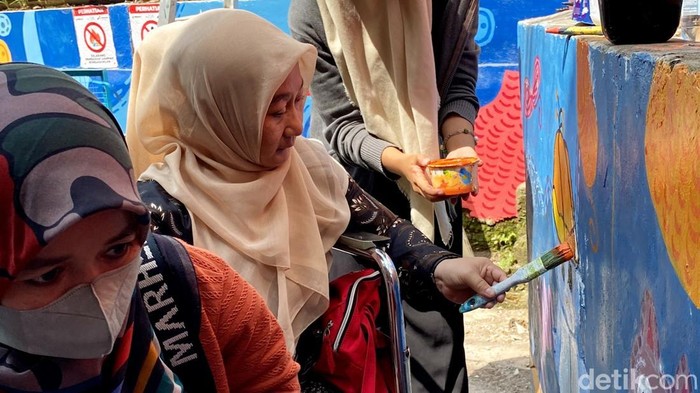 Elis, penyandang disabilitas daksa ikut kegiatan mural di Gang Masjid Kampung Rajut Binong Jati, Kota Bandung.
