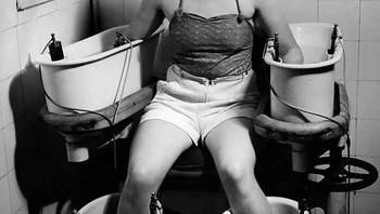 Seorang wanita muda memegang lengan dan kakinya di empat bak air berarus listrik, untuk meningkatkan sirkulasi darah, sekitar tahun 1938 Foto: Boredpanda