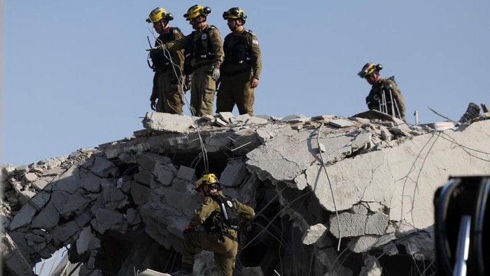 Rescue personnel work at an impact site following missile attack from Iran on Israel, in Rishon LeZion, Israel, June 14, 2025. REUTERS/Ronen Zvulun