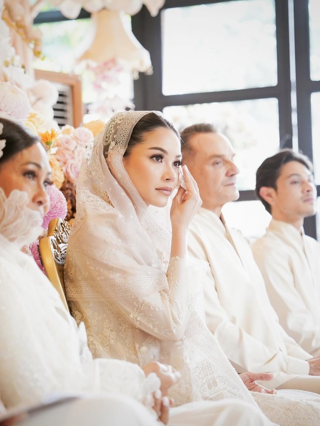 Untuk momen spesial ini, pesona anggun terpancar maksimal berkat busana yang dipakainya. Ia berbalut terusan bernuansa putih gading rancangan desainer kenamaan Sapto Djojokartiko, yang memadukan unsur klasik dengan estetika modern. (Foto: Instagram/@alyssadaguise)