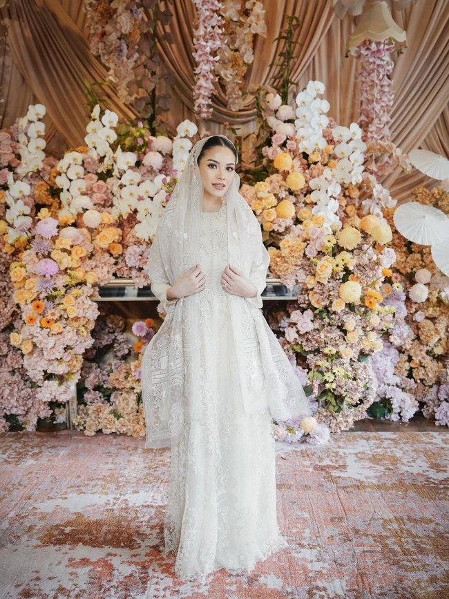 Gaun panjang bersiluet lurus yang dikenakan perempuan 27 tahun ini dihiasi bordir rumit dengan detail renda halus serta aksen motif floral yang memperkaya tekstur. Busana tersebut tampil begitu lembut dan feminin, menciptakan kesan suci yang sejalan dengan suasana spiritual pengajian. (Foto: Instagram/@alyssadaguise)