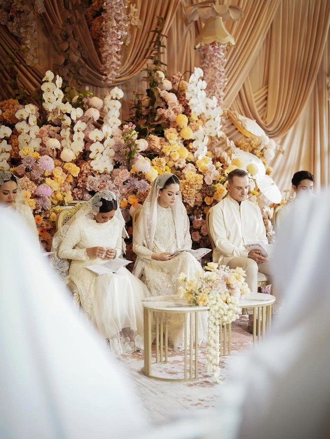 Palet warna bunga yang mendekorasi ruangan, terdiri dari mawar, krisan, dan anggrek dalam nuansa peach, krem, dan putih, turut mempermanis suasana, menyatu harmonis dengan tampilan Alyssa yang lembut dan berkelas. (Foto: Instagram/@alyssadaguise)