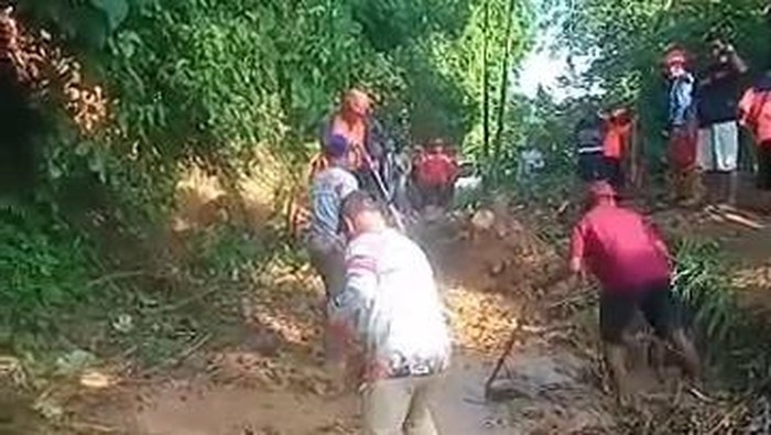 Proses pembersihan material banjir yang menutup akses ke Desa Pujiharjo Malang.
