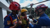 Para petugas damkar yang biasanya identik dengan operasi kebakaran, kali ini tampak sibuk membantu anak-anak memasang helm dan tali pengaman.