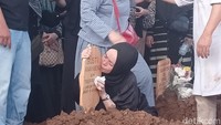 Ibunda Gusti Irwan Wibowo, Sri Yulianti mencium papan nisan anaknya.  Foto: Febri/detikhot