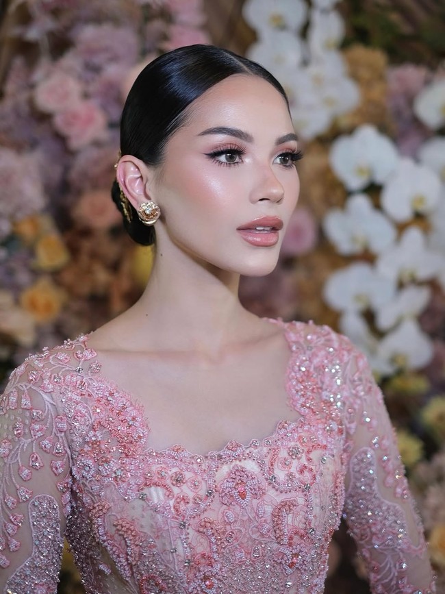 Wanita berdarah Prancis ini melengkapi penampilannya dengan anting bunga emas besar yang memberikan sentuhan feminin tanpa mengalihkan perhatian dari kebaya yang menjadi pusat tampilan. Foto: Instagram/@rhay_david