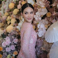 Kebaya dipenuhi sulaman berbentuk floral dan taburan payet kristal yang dirancang rumit, menciptakan kilau halus yang terlihat dramatis namun tetap lembut di bawah cahaya. Sentuhan warna keperakan dan nuansa fuchsia muda memperkaya tekstur busana. Foto: Instagram/@rhay_david