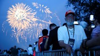 Ribuan warga memadati area National Mall untuk menyaksikan momen langka tersebut. Sorak sorai dan tepuk tangan menggema ketika langit dihiasi letupan cahaya emas, merah, dan biru warna khas bendera AS, menyatu dengan irama musik patriotik dari band militer. REUTERS/Carlos Barria