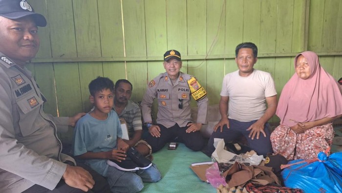 Polisi membantu Galang Ramadhan, siswa SD di Sulawesi Tengah yang viral menangis lantaran terancam putus sekolah. (dok.Polri)