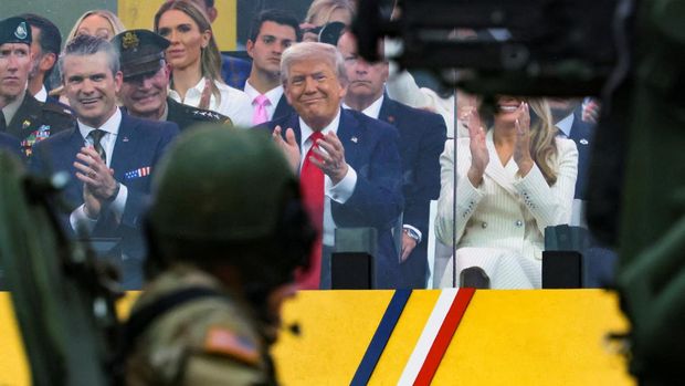 Presiden AS Donald Trump, Menteri Pertahanan AS Pete Hegseth dan ibu negara Melania Trump bertepuk tangan selama parade Ulang Tahun ke-250 Angkatan Darat AS, pada hari yang sama dengan ulang tahun ke-79 Presiden AS Donald Trump, di Washington, D.C., AS, 14 Juni 2025. (REUTERS/Carlos Barria)