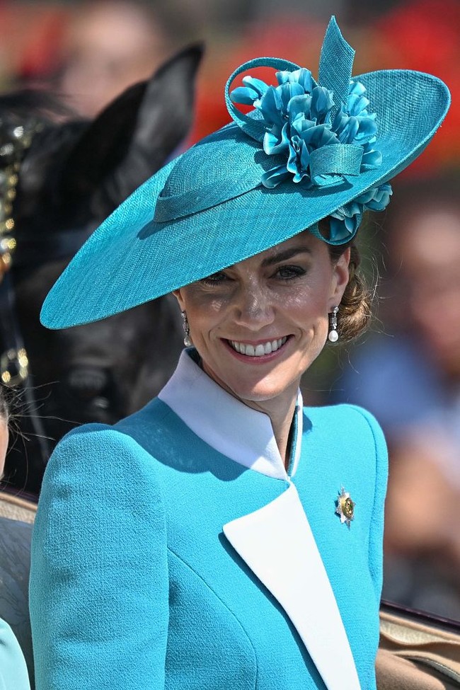 Dalam prosesi yang dimulai dari Istana Buckingham, Kate tampil anggun mengenakan coat dress biru rancangan Catherine Walker. Bagian atasan hadir dengan twist berupa lapel dan kerah asimetris. Ia kemudian melengkapi gayanya dengan topi lebar karya Juliette Botterill. (Foto: Rasid Necati Aslim/Anadolu via Getty Images)
