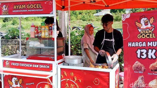Sil Lein (mengenakan kaca mata baju hitam) sedang menyiapkan ayam Goreng Celup (Gocel) di depan SMP Negeri 1 Larantuka, Sabtu (14/6/2025). (Yurgo Purab/detikBali)