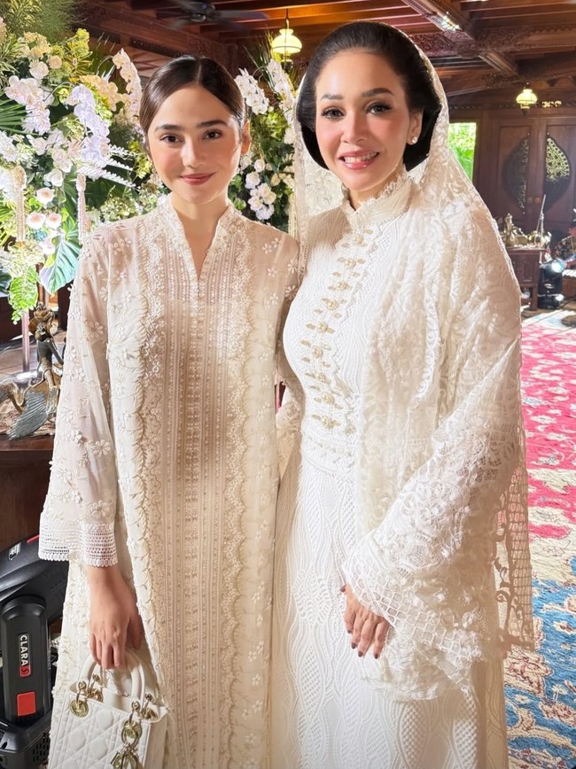 Dengan potongan lurus tanpa banyak aksen dramatis, gaun ini memberi siluet bersih dan elegan. Desainnya yang tertutup dan panjang sangat cocok untuk acara adat seperti prosesi siraman. Foto: Instagram/@syifahadju