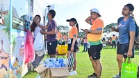 Warga antre memasukkan botol bekas minuman ke dalam mesin penukar botol plastik di kawasan Renon, Denpasar, Bali, Minggu (15/6). Dengan memasukkan botol plastik bekas ke dalam mesin, warga secara otomatis mendapatkan insentif berupa uang elektronik maupun kupon yang dapat digunakan untuk berbelanja. ANTARA FOTO/Fikri Yusuf