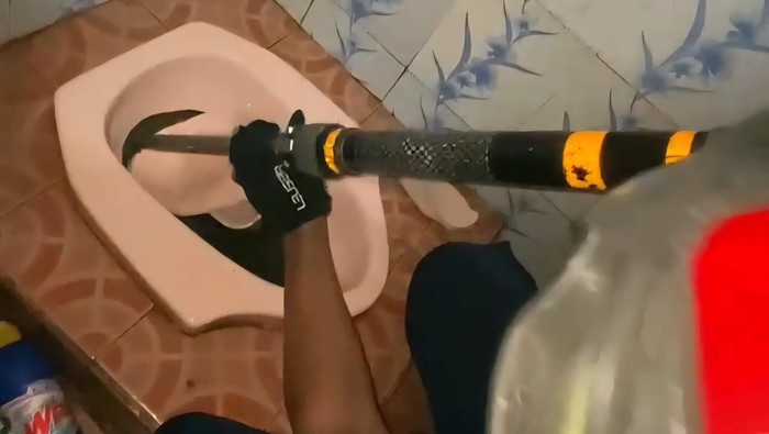 Foto: tangkapan layar video evakuasi ular sanca dalam lubang kloset (dokumen Dinas Damkar Kabupaten Bogor)