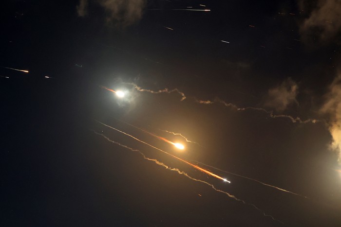 Rocket trails are seen in the sky above the Israeli coastal city of Netanya amid a fresh barrage of Iranian missile attacks on June 16, 2025. Israels military warned on June 16 that it had detected a new missile salvo from Iran, saying its defensive systems were working against the threat. (Photo by JACK GUEZ / AFP)
