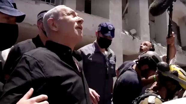 Perdana Menteri Israel Benjamin Netanyahu mengunjungi lokasi daerah permukiman yang hancur akibat serangan rudal Iran di dekat Tel Aviv, Israel, Minggu (15/6/2025). (Tangkapan Layar Video/REUTERS)