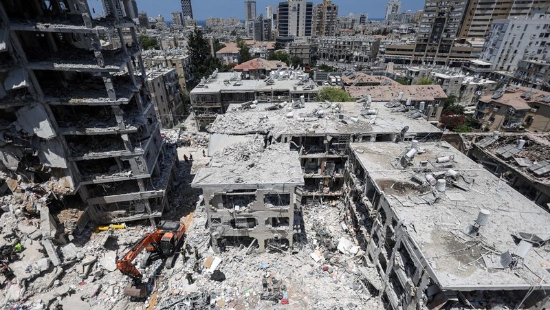 Emergency personnel work at an impact site after missiles were launched from Iran to Israel, in Tel Aviv, Israel, June 16, 2025. REUTERS/Ronen Zvulun