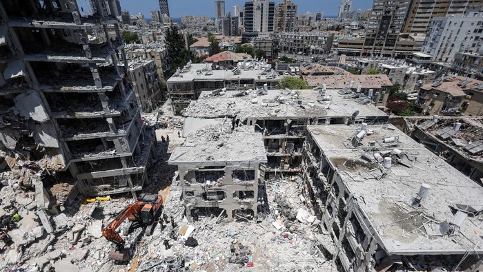 Rentetan Rudal Iran Sukses Hancurkan Kota-kota Israel Emergency personnel work at an impact site after missiles were launched from Iran to Israel, in Tel Aviv, Israel, June 16, 2025. REUTERS/Ronen Zvulun