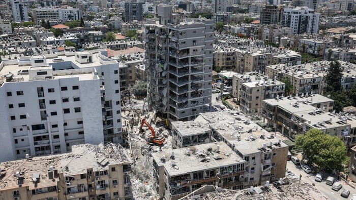 Emergency personnel work at an impact site after missiles were launched from Iran to Israel, in Tel Aviv, Israel, June 16, 2025. REUTERS/Ronen Zvulun