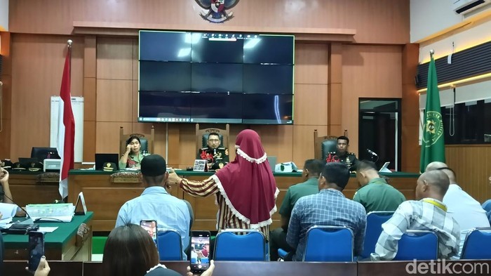 Saksi Syamsiah memperagakan Kopda Bazar membawa senjata api saat kejadian
