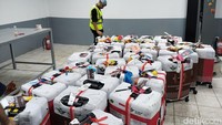 Setelah itu, koper akan dibuka oleh petugas penyortiran. Petugas akan mengeluarkan botol-botol berisi air zamzam dari koper jemaah. (Foto: Haris Fadhil/detikcom)