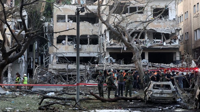 Sisa-sisa kepulan asap masih membubung di langit Tel Aviv, sementara puing-puing bangunan berserakan di jalanan. Serangan rudal yang diluncurkan Iran dalam eskalasi terbaru konflik di Timur Tengah telah menghantam salah satu sudut kota metropolitan Israel. REUTERS/Ronen Zvulun