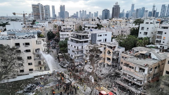 Wajah Salah Satu Sudut Kota Tel Aviv Usai Dihantam Rudal Iran Sisa-sisa kepulan asap masih membubung di langit Tel Aviv, sementara puing-puing bangunan berserakan di jalanan. Serangan rudal yang diluncurkan Iran dalam eskalasi terbaru konflik di Timur Tengah telah menghantam salah satu sudut kota metropolitan Israel. REUTERS/Ronen Zvulun