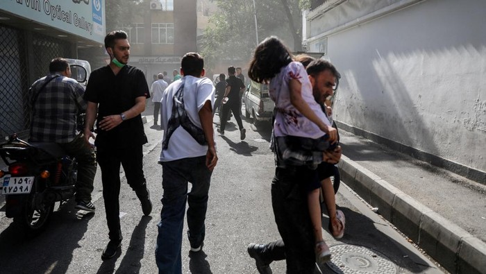 People run along a street amid smoke following the Israeli strikes on Iran, in Tehran, Iran, June 15, 2025. Hamid Amlashi/WANA (West Asia News Agency) via REUTERS   ATTENTION EDITORS - THIS PICTURE WAS PROVIDED BY A THIRD PARTY            TPX IMAGES OF THE DAY