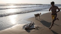 Di tengah serangan rudal Iran yang diluncurkan sebagai balasan atas serangan Israel, banyak warga Tel Aviv memilih untuk tetap melanjutkan aktivitas sehari-hari, termasuk menikmati pantai di tepi Mediterania. Meski sirene serangan udara sempat menggelegar, warga lokal dan turis terlihat duduk bersantai, bermain air, dan berjemur tanpa panik berlebihan. (REUTERS/Ronen Zvulun)  