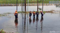 Sejumlah petugas Kereta Api melakukan pengecekan rel yang terendam banjir.