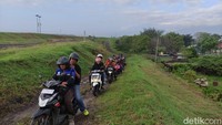 Sejumlah pengendara roda melintasi tanggul Lumpur Lapindo untuk menghidari banjir di Jalan Porong Lama.