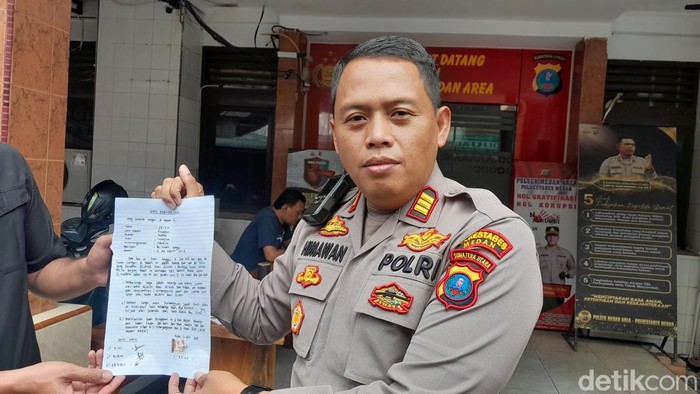 Kapolsek Medan Area AKP Dwi Himawan Chandra menunjukkan pernyataan tertulis keluarga. (Nizar Aldi/detikSumut)