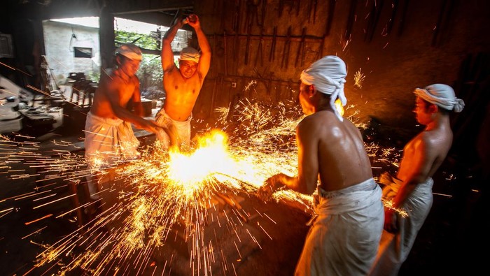 Panjak atau pembantu empu menempa batang logam saat proses pembuatan keris pusaka di Padepokan Keris Brojobuwono, Wonosari, Gondangrejo, Karanganyar, Jawa Tengah, Selasa (17/6/2025). Untuk membuat satu keris pusaka tersebut empu dan panjak membutuhkan waktu sekitar dua bulan hingga satu tahun karena dalam prosesnya harus menerapkan teknik tradisional yaitu dengan lelaku atau ritual tertentu untuk memenuhi kriteria keris pusaka tosan aji dan agar keris sesuai dengan kepribadian pemiliknya. ANTARA FOTO/Mohammad Ayudha