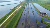 Dalam potret udara yang diambil Selasa (17/6), terlihat genangan air menguasai badan jalan, menciptakan pemandangan yang kontras dengan lalu lintas yang biasa padat. Truk-truk besar tampak terjebak di tengah genangan, sementara sejumlah warga nekat melintasi banjir demi aktivitas harian mereka. ANTARA FOTO/Umarul Faruq