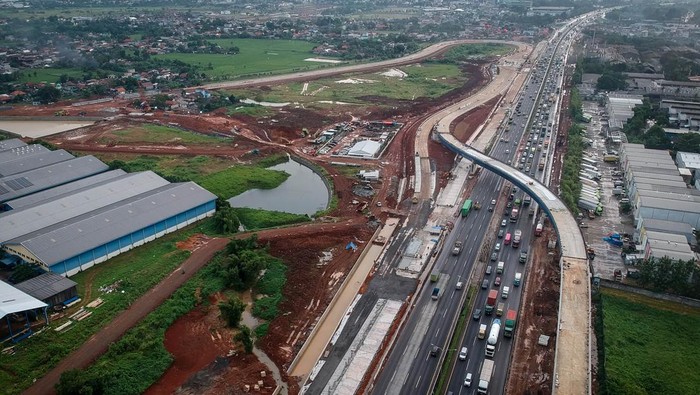 Proyek Tol KM 25 Jakarta-Merak Dikebut, Harapan Baru Atasi Macet Bitung Foto udara kendaraan melintas di dekat proyek pembangunan akses tol langsung KM 25 Jakarta-Merak di Curug, Kabupaten Tangerang, Banten, Selasa (17/6/2025). Pembangunan akses tol sepanjang 10 KM dan Gerbang Tol Bitung 3 itu sebagai solusi mengatasi kemacetan di Jalan Arteri Bitung hingga 10-15 persen yang ditargetkan selesai akhir tahun 2025. ANTARA FOTO/Putra M. Akbar/foc.