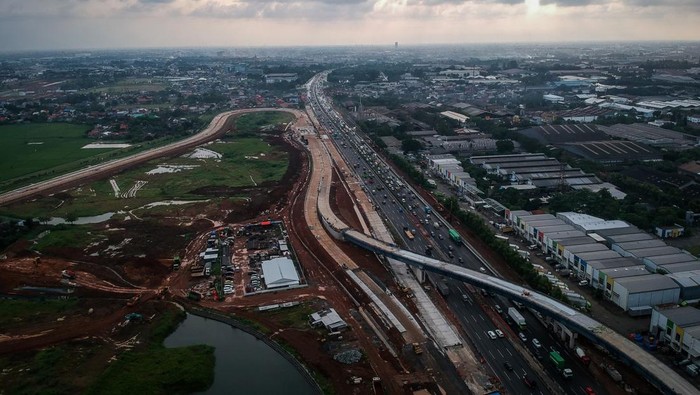 Proyek Tol KM 25 Jakarta-Merak Dikebut, Harapan Baru Atasi Macet Bitung Foto udara kendaraan melintas di dekat proyek pembangunan akses tol langsung KM 25 Jakarta-Merak di Curug, Kabupaten Tangerang, Banten, Selasa (17/6/2025). Pembangunan akses tol sepanjang 10 KM dan Gerbang Tol Bitung 3 itu sebagai solusi mengatasi kemacetan di Jalan Arteri Bitung hingga 10-15 persen yang ditargetkan selesai akhir tahun 2025. ANTARA FOTO/Putra M. Akbar/foc.