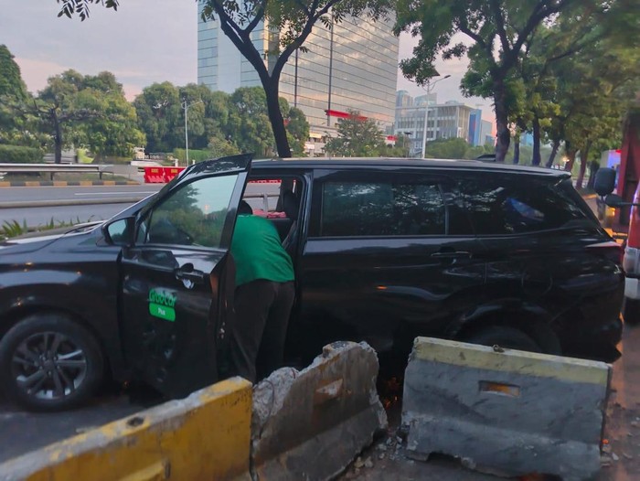 Satu unit taksi online mengalami kecelakaan menabrak separator busway hingga hancur berantakan di Jalan S. Parman, Jakbar. (dok.TMC Polda Metro Jaya)