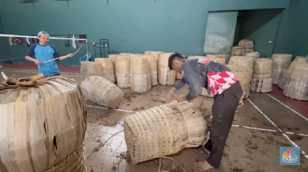 Seorang petani tembakau menata tembakaunya untuk disimpan di gudang penyimpanan di Temanggung, Jawa Tengah, Selasa (17/6/2025). (CNBC Indonesia/Tasya Natalia)