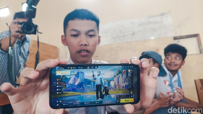 Siswa Menunjukkan Gim Online yang sering dimainkan di ponselnya