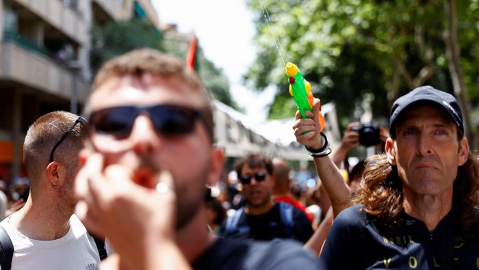 Warga Barcelona Gerah Diserbu Pelancong, Usir Turis dengan Semprotan Demonstrators hold a banner which reads
