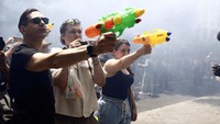 Demonstran menggunakan pistol air selama protes terhadap pariwisata massal, di Barcelona, Spanyol. Mengutip BBC, Selasa (17/6/2025), pasangan-pasangan turis yang duduk santai di kafe jalanan tampak kebingungan ketika mereka disemprot dengan pistol air. Sebuah toko pakaian mewah pun ditempeli stiker bertuliskan pesan penolakan terhadap para wisatawan yang mengunci diri di dalamnya. Foto: REUTERS/Bruna Casas