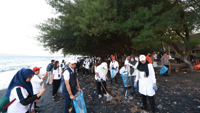 Bupati Banyuwangi bersama Asisten Deputi Bidang Energi, Sumber Daya Mineral dan Pariwisata Kementerian Sekretariat Negara Ida Dwi Nilasari membersihkan sampah di pantai Grand Watu Dodol Banyuwangi.