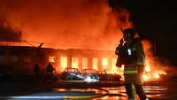 Warga sekitar tampak menyaksikan dari kejauhan saat petugas berusaha menanggulangi dampak serangan. Belum ada laporan korban jiwa resmi. REUTERS/Stringer
