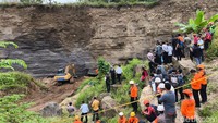Masyarakat tampak menyaksikan proses evakuasi dua penambang galian C yang tertimbun. Untuk memudahkan pencarian, Basarnas menggunakan ekskavator untuk mencari korban yang tertimbun.