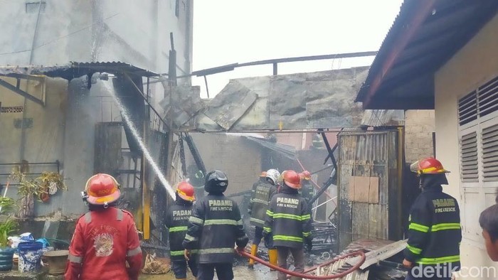 Sejumlah petugas damkar menyemprotkan air ke arah bangunan yang terbakar di Padang, Sumbar. (Jeka Kampai/detikSumut)