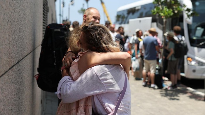 Takut Rudal Iran, WNA Ramai-ramai Kabur dari Israel A man holds passports, as people of foreign nationalities gather to leave Israel on buses via Egypt, following a missile attack from Iran, in Tel Aviv, Israel, June 17, 2025. REUTERS/Ronen Zvulun