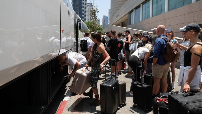 A man holds passports, as people of foreign nationalities gather to leave Israel on buses via Egypt, following a missile attack from Iran, in Tel Aviv, Israel, June 17, 2025. REUTERS/Ronen Zvulun