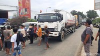 Massa mencegat truk lain yang melintas untuk diajak ikut aksi bersama.
