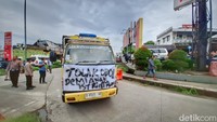 Beberapa truk nampak dilengkapi dengan spanduk protes kebijakan tersebut. Kemudian tidak hanya truk, beberapa angkutan bak terbuka turut melakukan aksinya di sepanjang jalan tersebut.